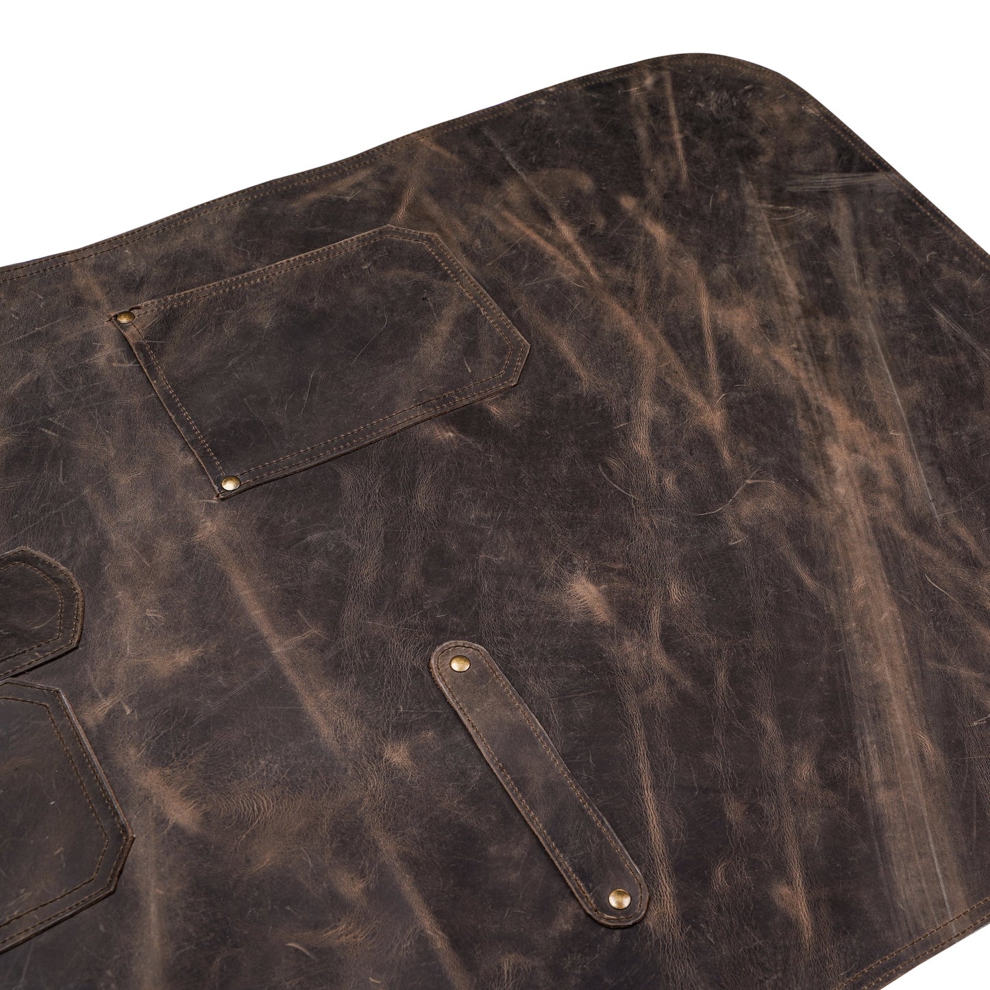 Close-up image of handcrafted pullup leather chef apron, focusing on leather texture, reinforced stitching, and brass buckle detailing. Captures premium craftsmanship, ideal for showcasing personalization area. Great for chefs, BBQ pros, and hairstylists looking for functional and elegant workwear.

