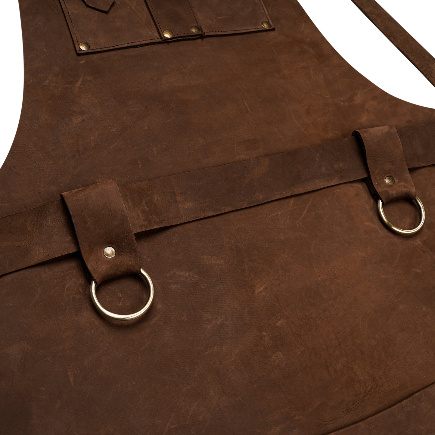 Close-up of premium full-grain cowhide leather apron showcasing rich texture, reinforced stitching, sturdy brass hardware, and towel ring details. Highlights the craftsmanship and rugged quality perfect for grilling, barbering, or workshop use. Ideal image for showcasing personalized engraving and fine leather grain in professional-grade aprons.

