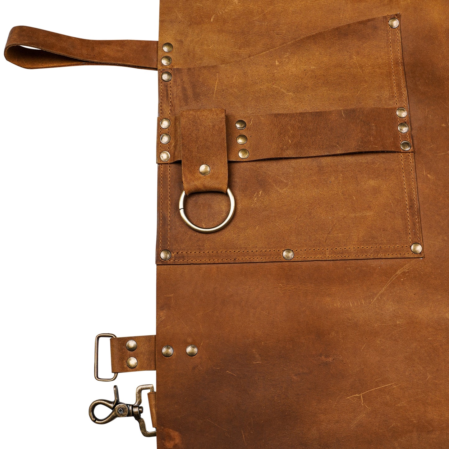 Detailed close-up of Ironhide Work Apron’s tool loops, pockets, and textured pull-up cowhide leather. Thick leather surface and premium brass hardware reflect quality craftsmanship. Ideal for hands-on professionals and hobbyists who demand strength, comfort, and performance from their workshop gear.


