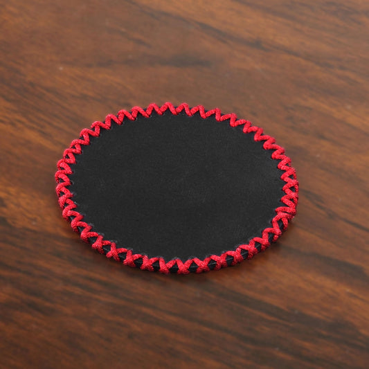 Detailed close-up view of the handknitted lace stitching around the leather coaster edge, showcasing craftsmanship, thread variety, and premium cowhide surface texture.

