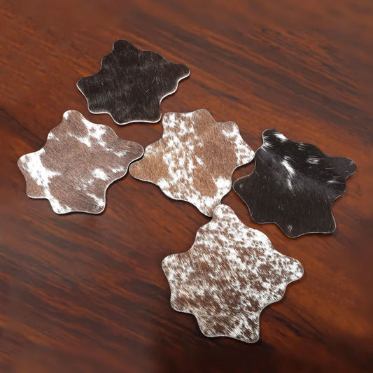 Set of natural hair-on leather coasters displayed on a white background, showcasing unique cowhide patterns, soft-touch surface, and perfect round shape ideal for bar or table use.

